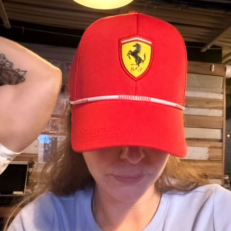 A fan in a red Ferrari cap